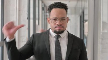 Başparmakları aşağıda kameraya bakan İspanyol iş adamının portresi