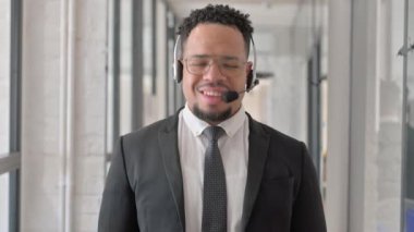 Çağrı merkezinde kulaklığı olan gülümseyen İspanyol adamın portresi.