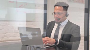 Kulaklıklı İspanyol İşadamı, Çağrı Merkezi 'nde Laptop ile Video Sohbeti Yapıyor