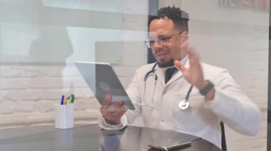 Tablet aracılığıyla çok ırklı erkek doktordan çevrimiçi görüntülü sohbet
