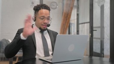 Kulaklığı Çağrı Merkezi 'nde olan çok ırklı İşadamı Laptop ile Video Sohbeti Yapıyor