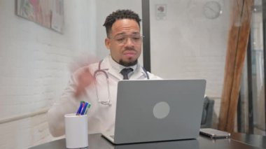 İspanyol genç doktor video sohbetinde hastayla konuşuyor.
