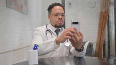 İspanyol genç doktor telefonda mesaj yazıyor.