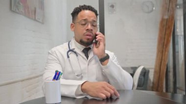 İspanyol genç doktor telefonda konuşuyor.