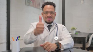 Başparmakları havada erkek doktorun portresi Kameraya bakıyor