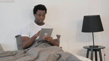 Afrikalı Adam Yatakta Otururken Dijital Tablet Kullanıyor