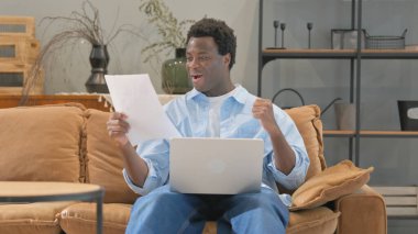 Kucağında dizüstü bilgisayarla evrak işi yapan Afrikalı adama tezahürat yapmak