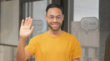 Merhaba demek için el sallayan sıradan Afrikalı genç adamın portresi.