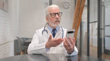 Kıdemli Erkek Doktor Telefonda Video Sohbeti Yapıyor