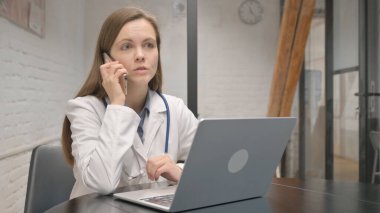 Genç erkek doktor hastanede telefonda konuşuyor