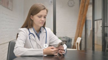 Genç Kadın Doktor İş yerinde Telefonu Kullanıyor