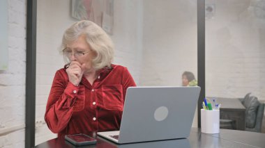 Dizüstü bilgisayarda çalışırken öksüren Kıdemli Yetişkin Kadın