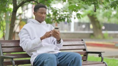 Açık havada telefon kullanırken Afro-Amerikan Adam Üzüntüsünü Açıklıyor