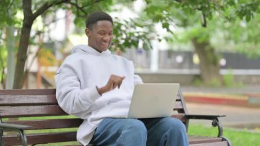 Günlük Afrikalı Amerikalı Adam Park 'taki laptopta video görüşmesi yapıyor.