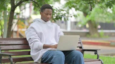 Sıradan bir Afrikalı Amerikalı Laptop 'u açık havada düşürüyor.