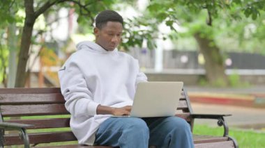 Park 'taki Afro-Amerikan Adam dizüstü bilgisayarla kameraya bakarken şok oldu.