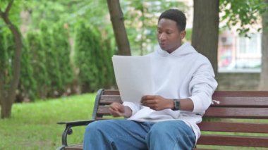 Genç Afrikalı Adam Bench 'te Evrak Okuyor