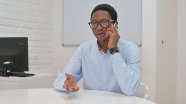 Genç Afrikalı İşadamı Müşteriyle telefonda konuşuyor