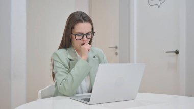 Young Woman Coughing while Working on Laptop