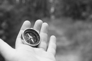 Pusula ile turizmin sembolü olarak doğal arka planda yuvarlak pusula ve pusula ile seyahat ve pusula ile açık hava aktiviteleri