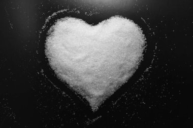 Siyah arka plan üzerinde beyaz şekerden yapılmış tatlı kalp görüntüsü ile retro tarzı soyut siyah beyaz fotoğraf
