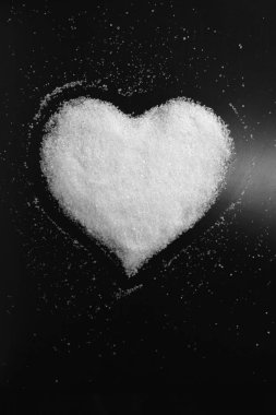 Siyah arka plan üzerinde beyaz şekerden yapılmış tatlı kalp görüntüsü ile retro tarzı soyut siyah beyaz fotoğraf