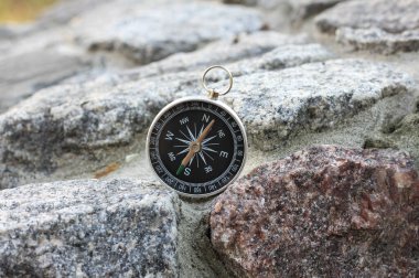 Pusula ile turizmin sembolü olarak doğal arka planda yuvarlak pusula ve pusula ile seyahat ve pusula ile açık hava aktiviteleri