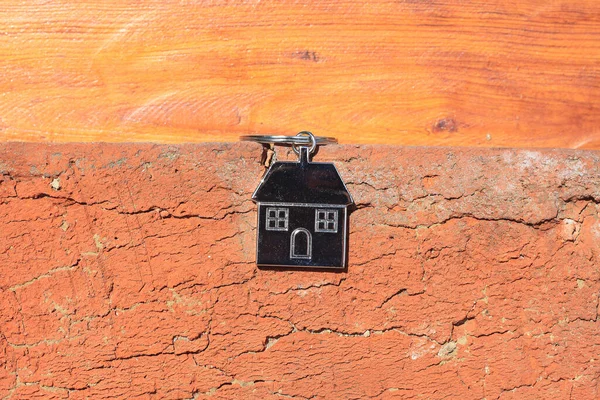 木の背景に鍵チェーンの形で抽象的な家 — ストック写真