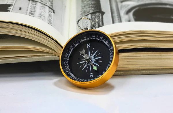 Classic round compass and book as symbol of tourism with compass, travel with compass and outdoor activities with compass