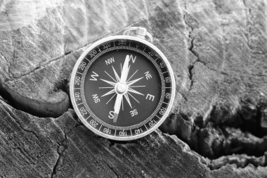 Pusula ile turizmin sembolü olarak siyah ve beyaz fotoğraf, pusula ile seyahat ve pusula ile açık hava aktiviteleri