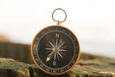 Pusula ile turizmin sembolü olarak doğal arka planda yuvarlak pusula, pusula ile seyahat ve pusula ile açık hava aktiviteleri