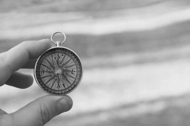 Pusula ile turizmin sembolü olarak doğal arka planda klasik navigasyon pusulası, pusula ile seyahat ve pusula ile açık hava aktiviteleri