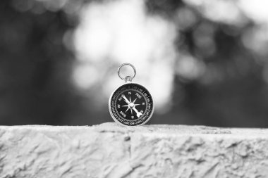 Pusula ile turizmin sembolü olarak doğal arka planda klasik navigasyon pusulası, pusula ile seyahat ve pusula ile açık hava aktiviteleri