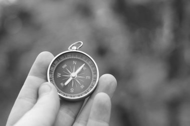 Pusula ile turizmin sembolü olarak doğal arka planda klasik navigasyon pusulası, pusula ile seyahat ve pusula ile açık hava aktiviteleri