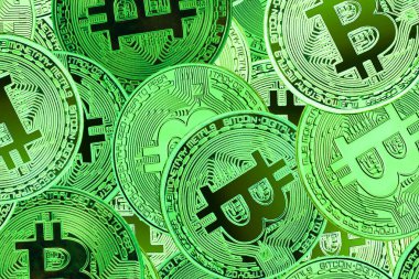 Bitcoin 'lerin zenginliğinin sembolü olarak altın bitcoin' lerin arka planındaki diğer bitcoin 'lerin yanında yuvarlak bitcoin' ler