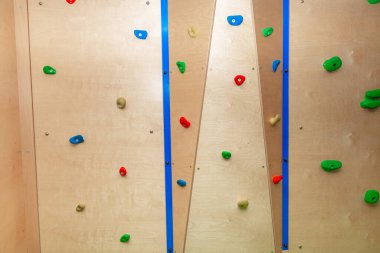 Tutmak için birçok renkli kavrama ile duvara tırmanmak