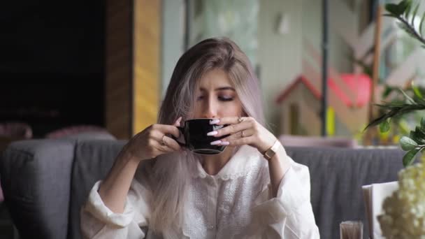 Genç Sarışın Kadını Bir Restoranın Penceresinde Kahve Içiyor Akıllı Telefona — Stok video