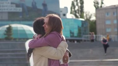 Young african american woman is meeting with a business partner or client and discussing future plans for a project, hugging her friend