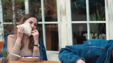 Genç bir çift. Denim giysileri. Eski bir restoranda randevuda, dışarıda. Konuşuyorlar. Sallanıyorlar.