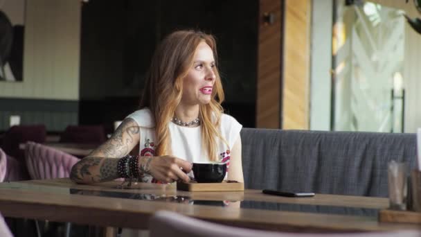 Ung Kvinna Ledig Klädsel Sitter Vid Fönstret Ett Café Och — Stockvideo