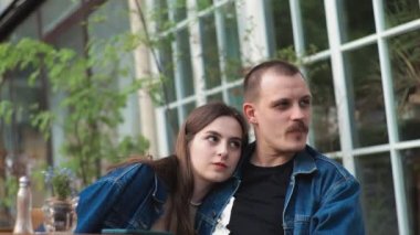 Genç bir çift. Denim giysileri. Eski bir restoranda randevuda, dışarıda. Konuşuyorlar. Harikaydı. Sarılmak..