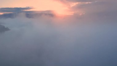 Güneşin doğuşundaki bulutlarda uçuşun hava aracı görüntüsü. Bulutlar kamerada hareket ediyor. Sonsuzluk kavramı, uçmak, rahatlamak, özgürlük, barış