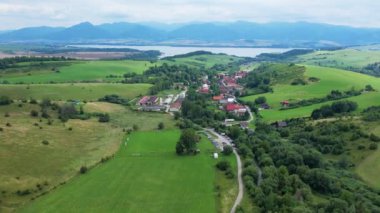 Dağlara, köylere, tarlalara, Slovakya 'daki Liptovska Mara yakınlarındaki yeşil ormana insansız hava aracı görüntüsü