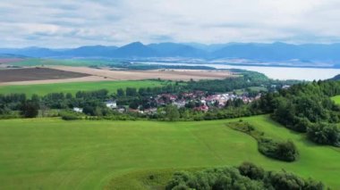 Dağlara, köylere, tarlalara, Slovakya 'daki Liptovska Mara yakınlarındaki yeşil ormana insansız hava aracı görüntüsü