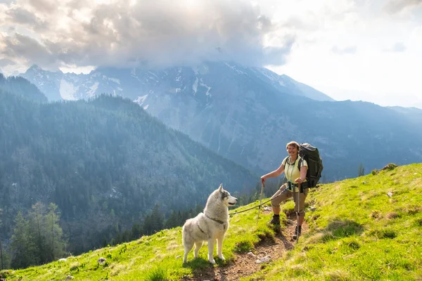 アルプスの山々にぽっちゃりとしたスポーティ女性 ペット 冒険の概念で旅行する — ストック写真
