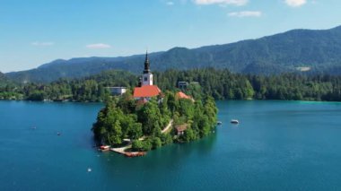 Slovenya, Bled Gölü 'nde Meryem' in Hacı Kilisesi. Yazın mavi göl ve arka planda dağlar. Yörünge atışı.
