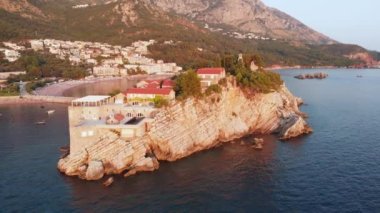 Karadağ 'ın küçük eski Sveti Stefan ve tatil beldesi Petrovac' ın insansız hava aracı videosu.