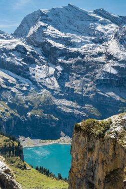 Oeschinensee Gölü 'nün Idyllic sabah manzarası. İsviçre Alpleri, İsviçre, Kandersteg Bölgesi. Arka planda çam ağaçları ve dağlar olan mavi dağ gölü.