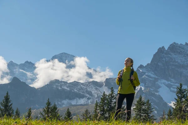 瘦小的女人站在雪山前欣赏瑞士的自然风光 流浪情欲 自然之美 — 图库照片