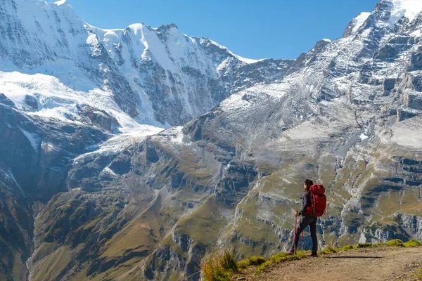 雪の山の前に立ってスイスの自然を楽しむスポーティ女性 スポーツ 自然の美しさ ストック画像